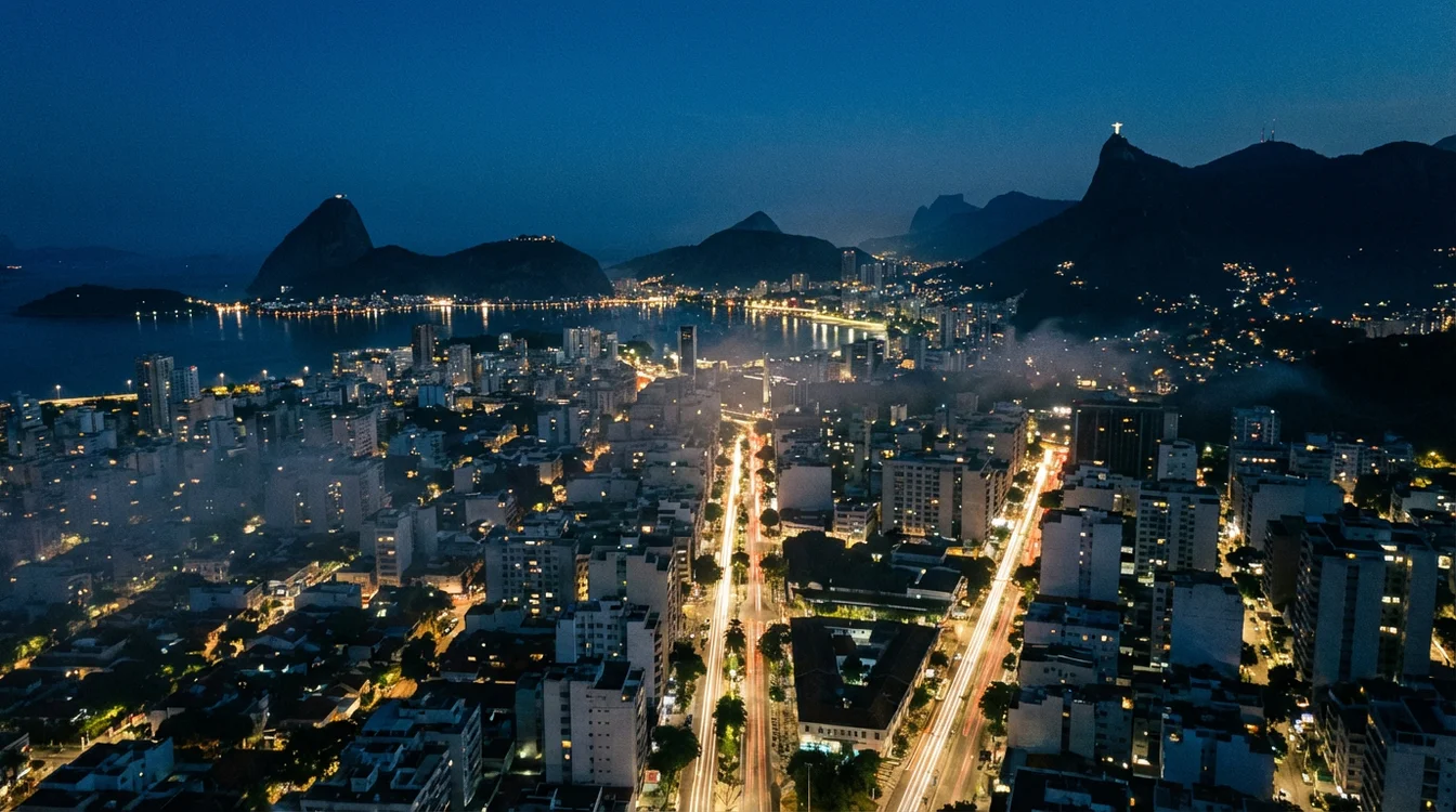 Vista noturna do Rio de Janeiro com luzes da cidade refletindo na Baía de Guanabara